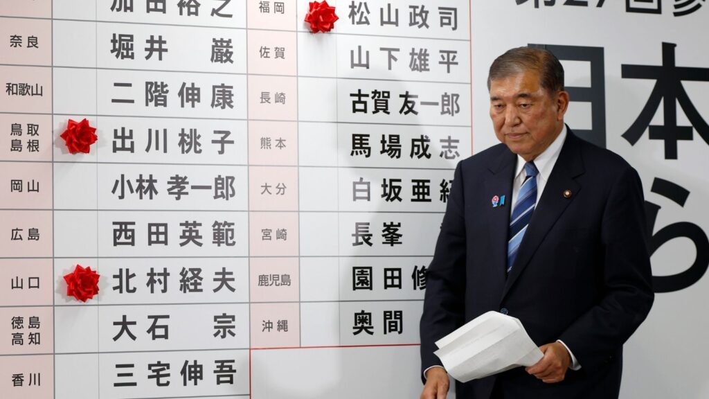 Shigeru Ishiba, Japan's Prime Minister and president of the ruling Liberal Democratic Party (LDP), walks before a board with few red paper roses showing elected candidate at the LDP headquarters in Tokyo, Sunday, July 20, 2025