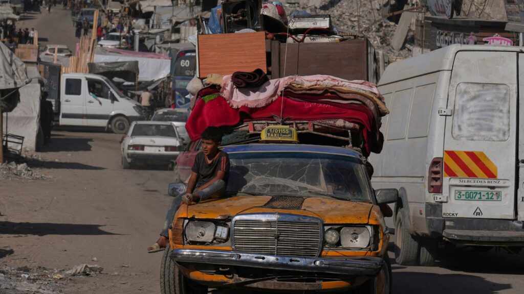 Displaced Palestinians fleeing northern Gaza Strip move with their belongings on a street in Gaza City, Thursday, Aug. 28, 2025. (AP Photo/Abdel Kareem Hana)