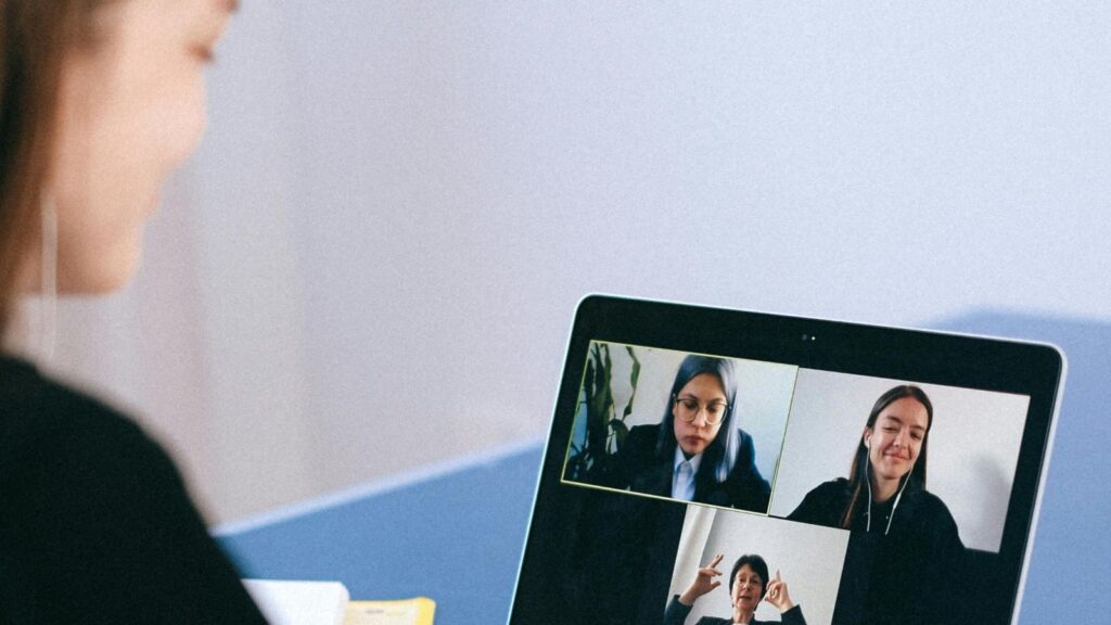 women on laptop screen as another woman looks on