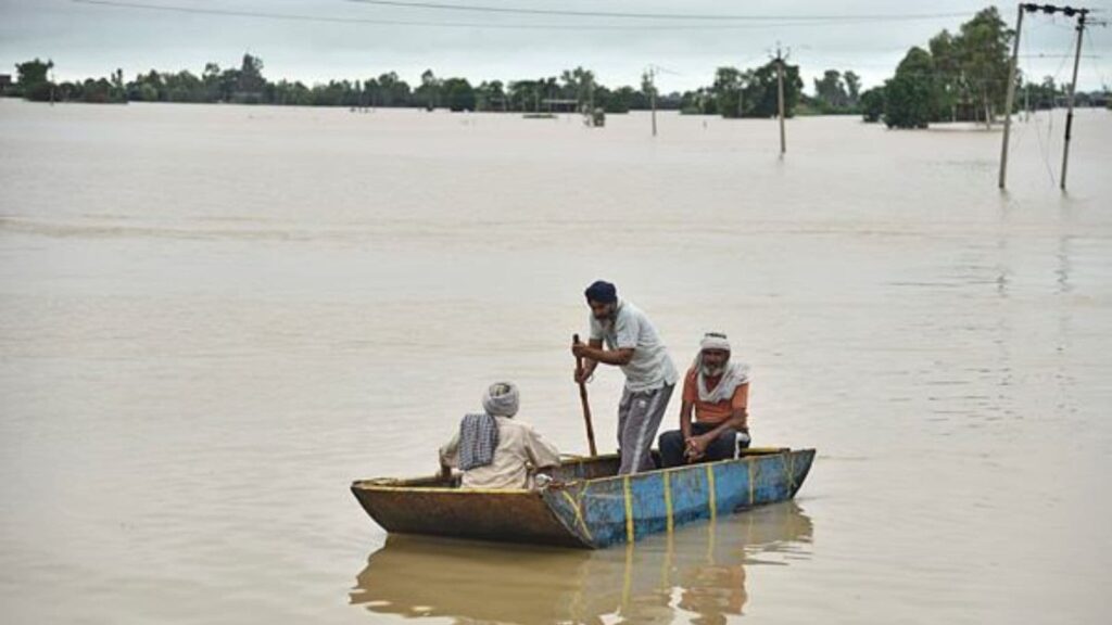 Villagers travel by boat to reach their homes cut off by floodwaters following heavy rains in Kapurthala district of northern state of Punjab, India